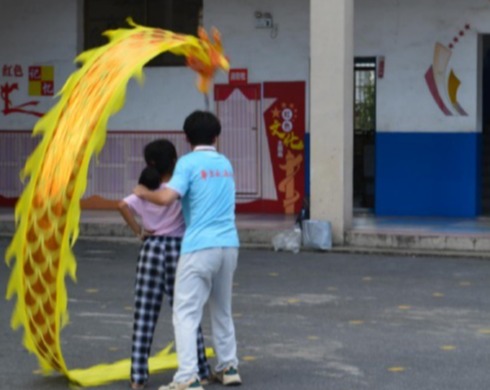 图为实践队员教授学生如何舞八字龙。通讯员 张贵摄